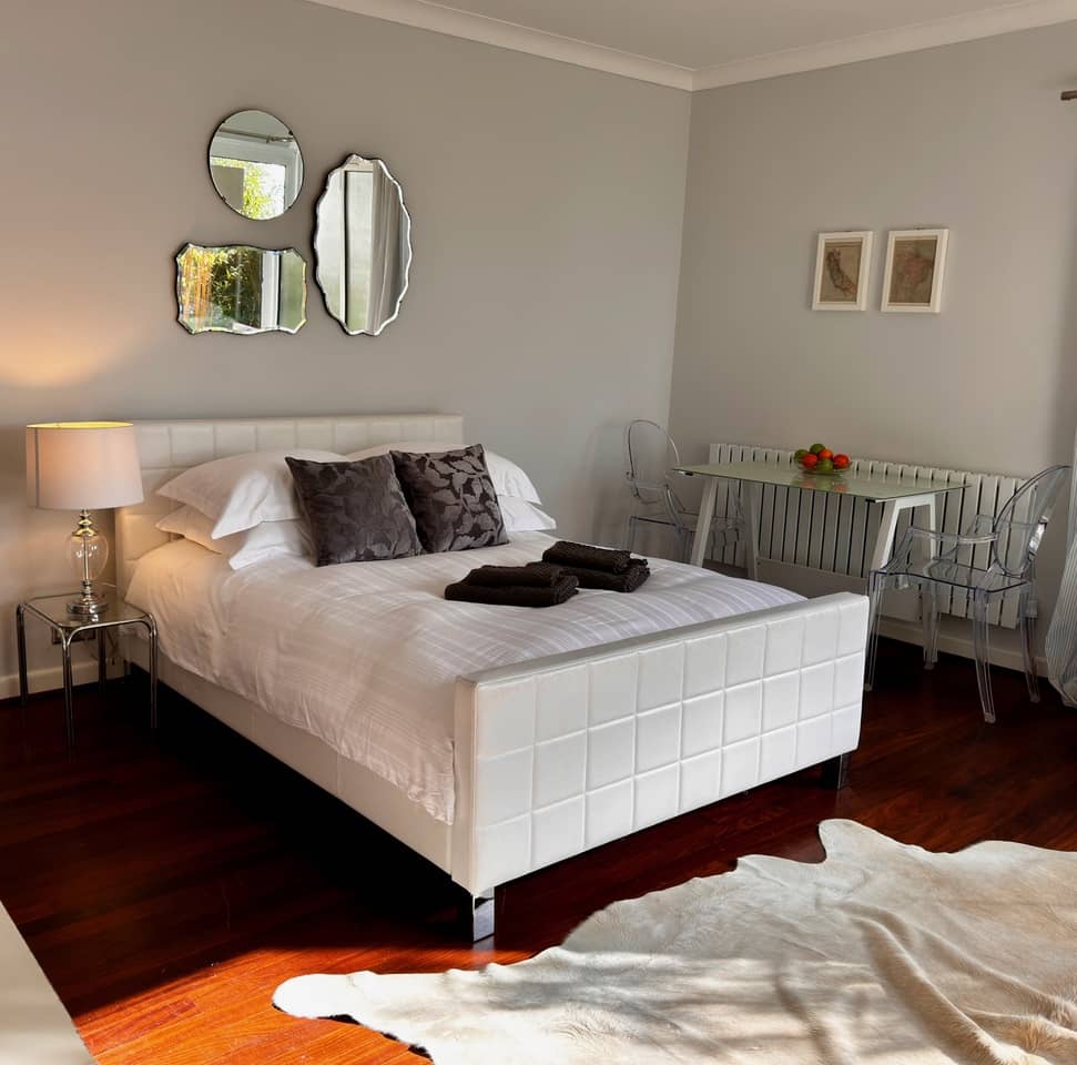 White bed in a room with wooden floors